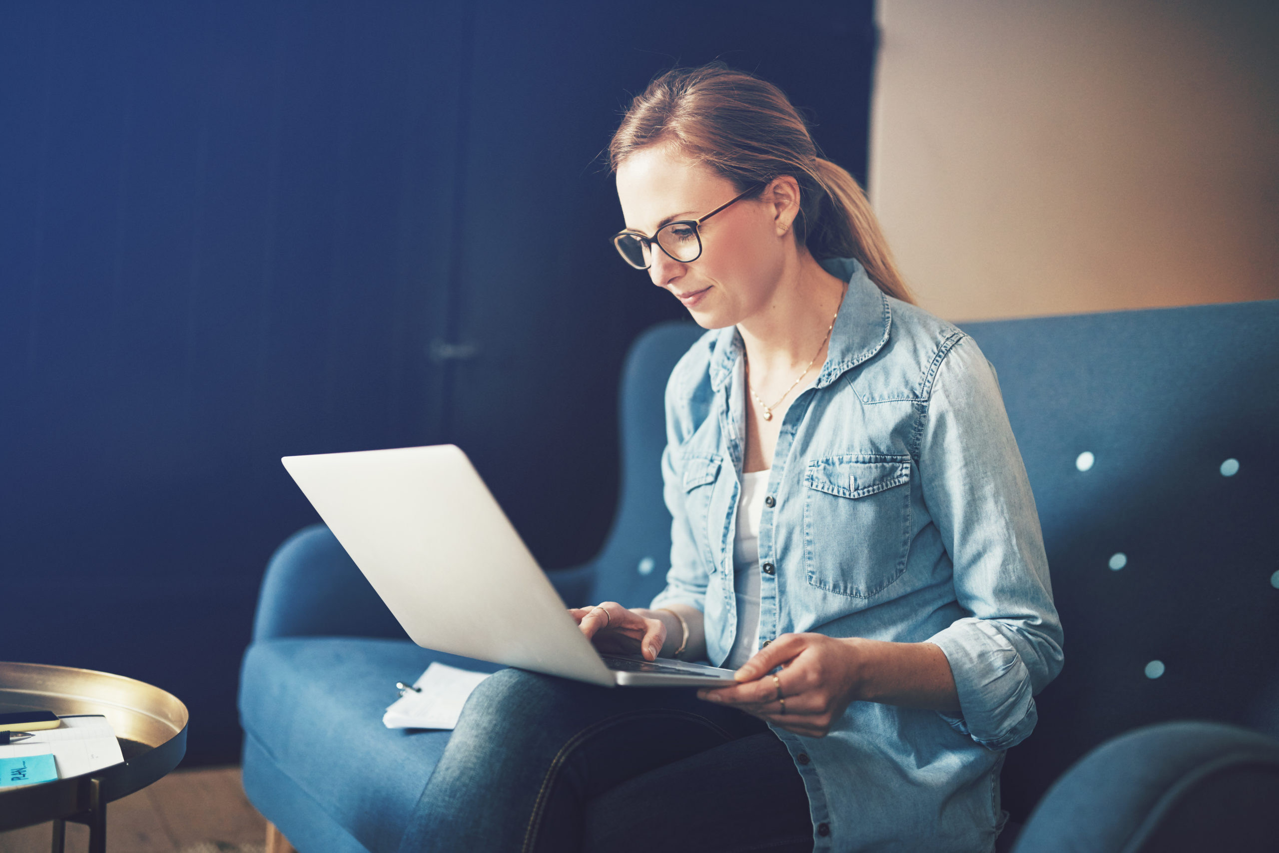 Smiling young female entrepreneur working online with a laptop